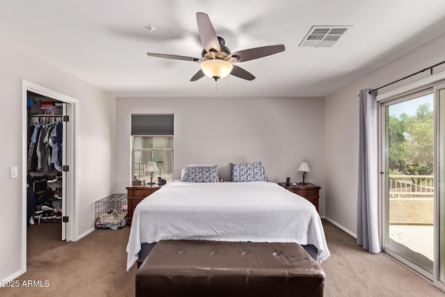 7031 W Lone Tree Trl, Peoria, AZ 85383 - bedroom with light colored carpet, access to exterior, a walk in closet, and a ceiling fan
