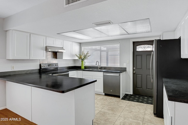 3106 S Extension Rd, Mesa, AZ 85210 - kitchen featuring appliances with stainless steel finishes, under cabinet range hood, a peninsula, a sink, and dark countertops