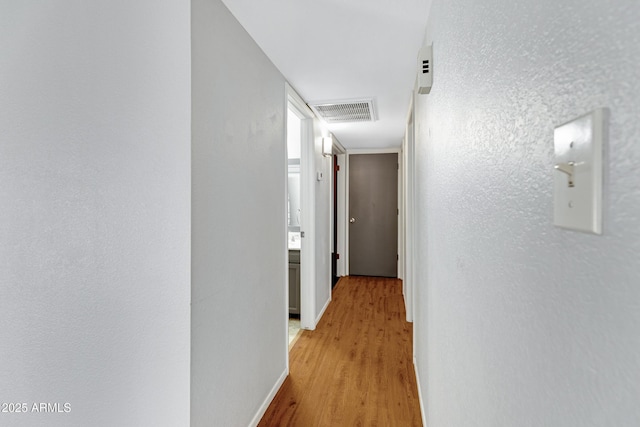 3106 S Extension Rd, Mesa, AZ 85210 - hallway with light wood-type flooring, baseboards, and a textured wall
