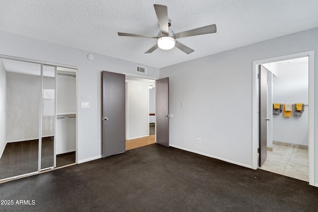 3106 S Extension Rd, Mesa, AZ 85210 - unfurnished bedroom featuring a closet, ensuite bathroom, a textured ceiling, ceiling fan, and baseboards