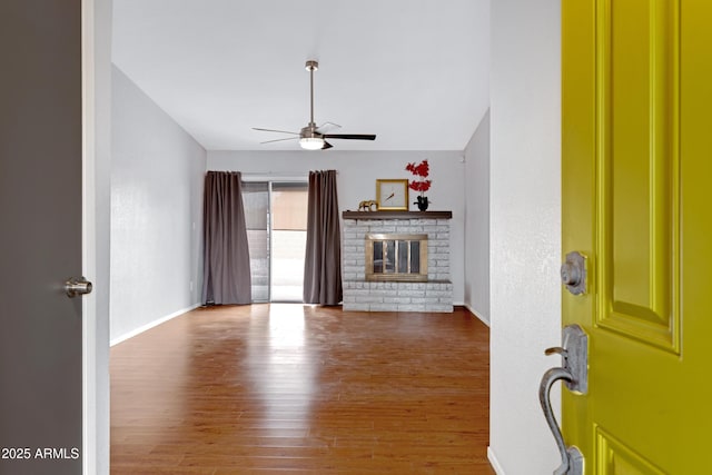 3106 S Extension Rd, Mesa, AZ 85210 - unfurnished living room featuring ceiling fan, wood finished floors, a fireplace, and baseboards