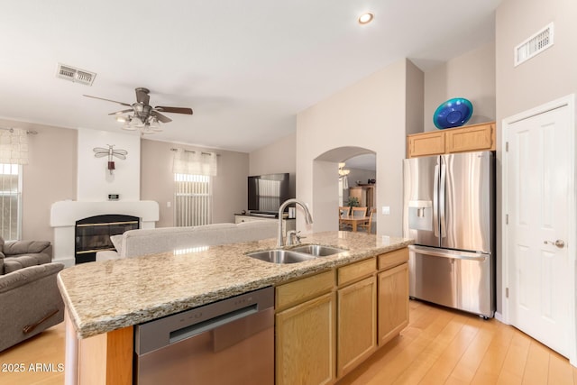 3412 E Kristal Way, Phoenix, AZ 85050 - kitchen with stainless steel appliances, a sink, open floor plan, light brown cabinetry, and arched walkways