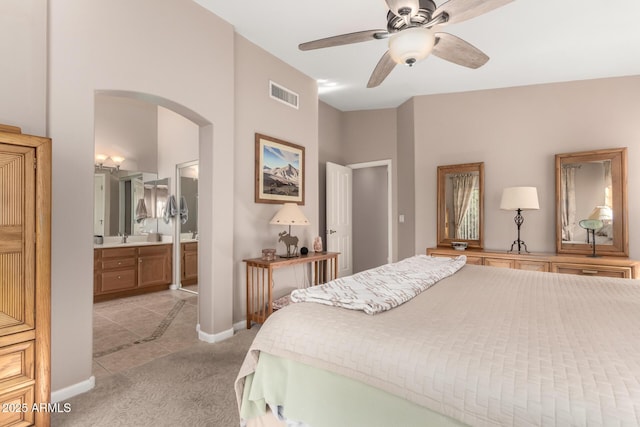 3412 E Kristal Way, Phoenix, AZ 85050 - bedroom with arched walkways, light colored carpet, light tile patterned floors, baseboards, and a sink