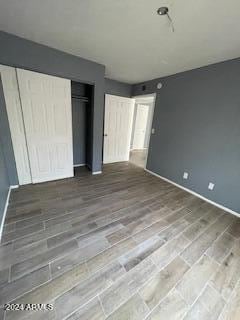 unfurnished bedroom with a closet and hardwood / wood-style flooring