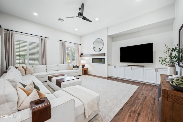 living area featuring a ceiling fan, visible vents, wood finished floors, and recessed lighting