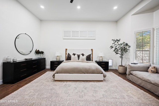 bedroom with baseboards, wood finished floors, and recessed lighting