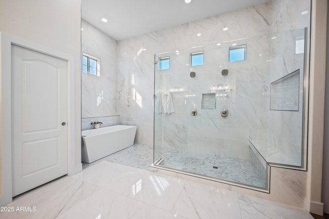 bathroom featuring recessed lighting, a freestanding bath, and a marble finish shower