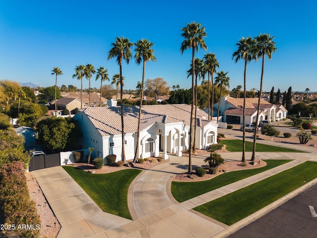 mediterranean / spanish-style home featuring a residential view, a gate, and concrete driveway