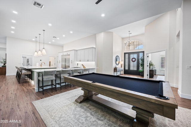 playroom featuring recessed lighting, visible vents, a towering ceiling, and wood finished floors