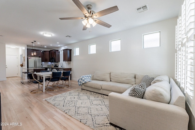 living room with light hardwood / wood-style flooring and ceiling fan