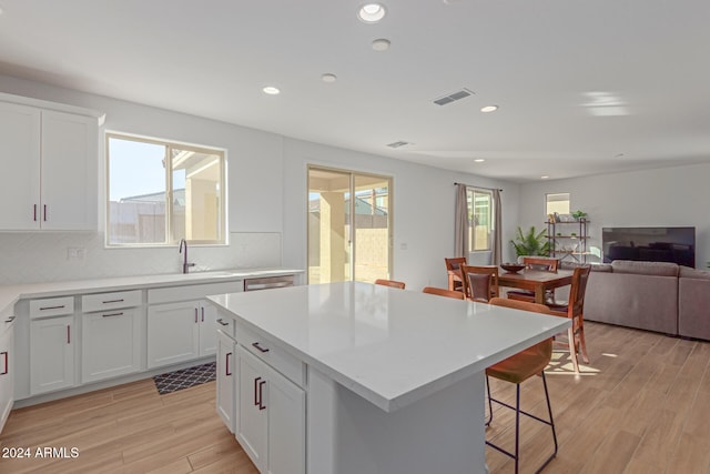 kitchen featuring white cabinets, a healthy amount of sunlight, and light wood-type flooring