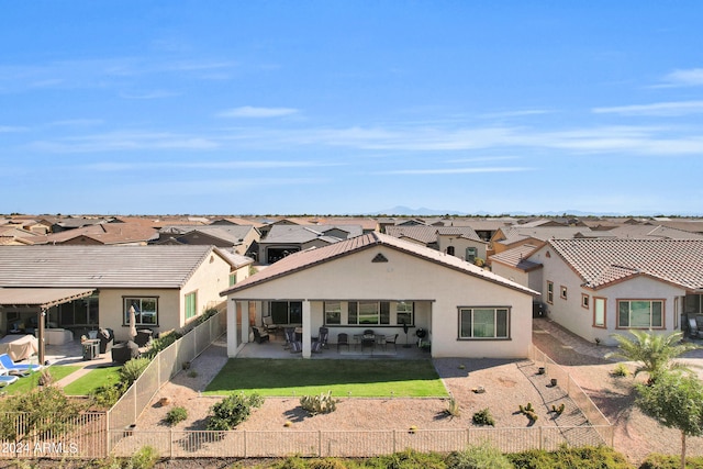 rear view of house with a yard, an outdoor living space, and a patio