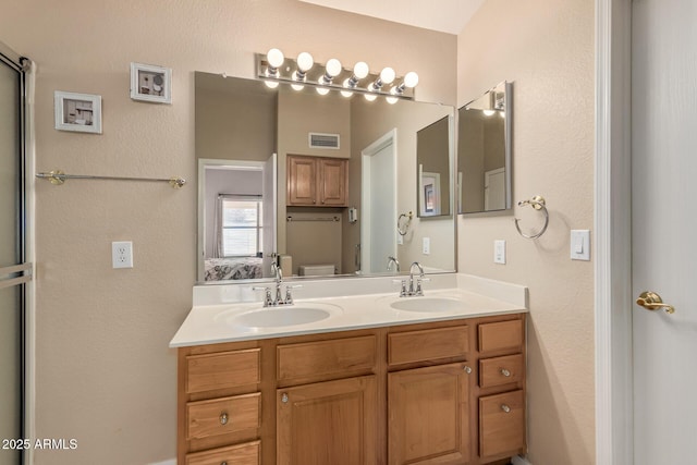bathroom with visible vents, a sink, toilet, and double vanity