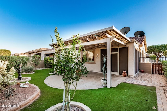 back of property featuring a lawn and a patio