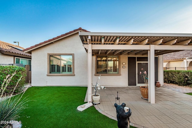 rear view of property with a pergola, a yard, and a patio