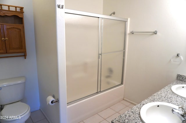 full bathroom with tile patterned floors, vanity, toilet, and bath / shower combo with glass door