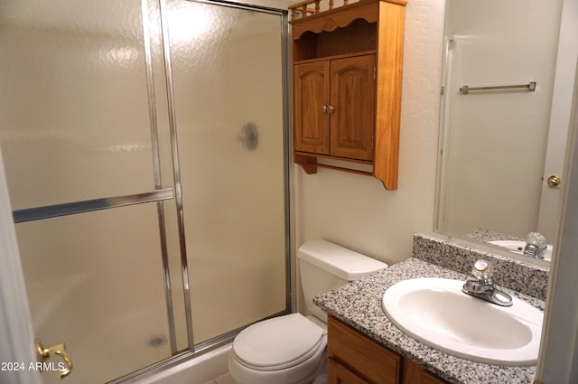 bathroom featuring vanity, toilet, and an enclosed shower