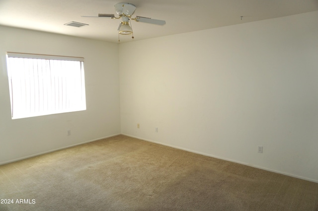 unfurnished room with ceiling fan and light carpet