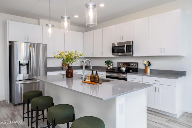 651 N Ironwood Dr Unit 8, Apache Junction, AZ 85120 - kitchen with appliances with stainless steel finishes, a sink, a kitchen bar, light wood finished floors, and white cabinetry