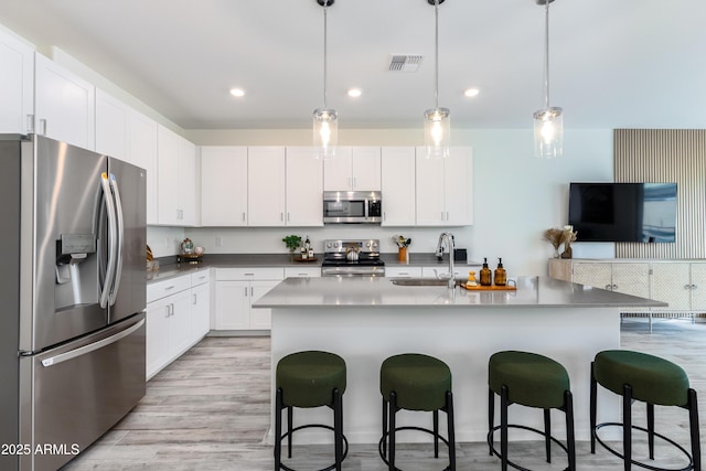 651 N Ironwood Dr Unit 8, Apache Junction, AZ 85120 - kitchen featuring stainless steel appliances, a sink, a kitchen breakfast bar, light wood finished floors, and white cabinets