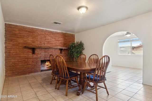 tiled dining room featuring a fireplace