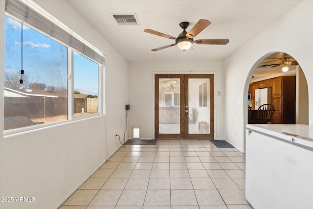 interior space featuring french doors, ceiling fan, and light tile patterned floors