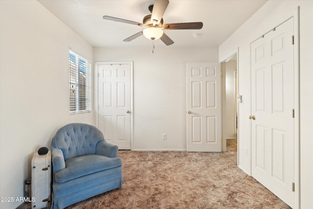 living area featuring light colored carpet and ceiling fan