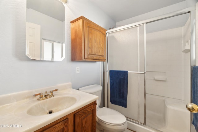 bathroom with vanity, toilet, and a shower with shower door