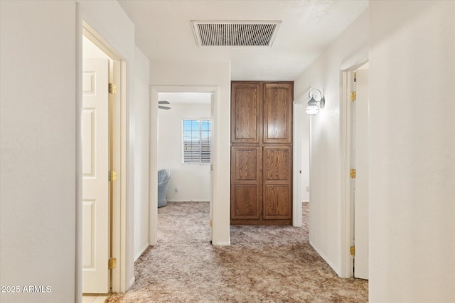 hallway featuring light colored carpet