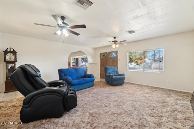 carpeted living room with ceiling fan