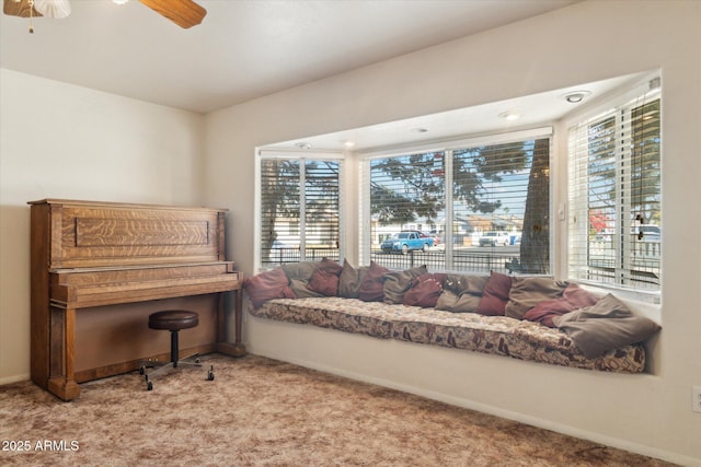 sitting room with ceiling fan, light colored carpet, and a healthy amount of sunlight