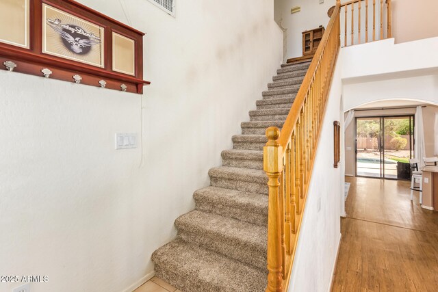 3381 E Canary Way, Chandler, AZ 85286 - stairs featuring arched walkways, wood finished floors, and a high ceiling