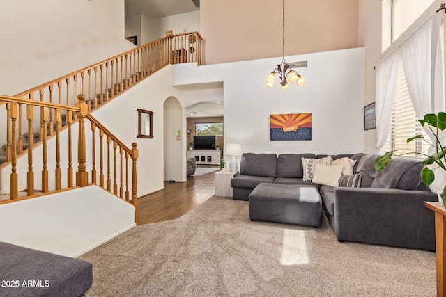 3381 E Canary Way, Chandler, AZ 85286 - living room with carpet floors, arched walkways, a chandelier, stairway, and a high ceiling