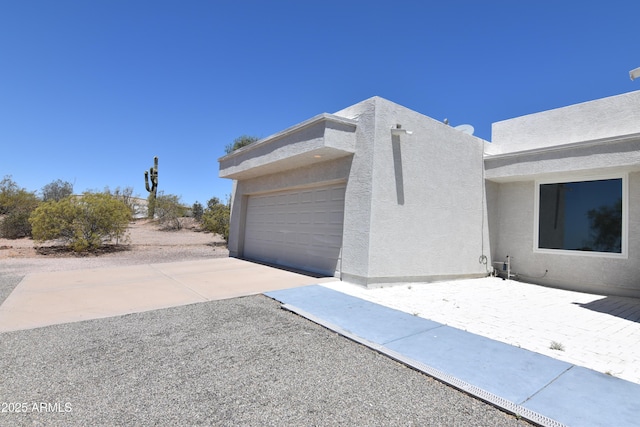 2570 E Manzanita St, Apache Junction, AZ 85119 - view of side of property featuring stucco siding, an attached garage, and concrete driveway