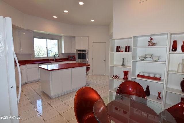 2570 E Manzanita St, Apache Junction, AZ 85119 - kitchen with oven, freestanding refrigerator, a sink, light tile patterned floors, and a center island