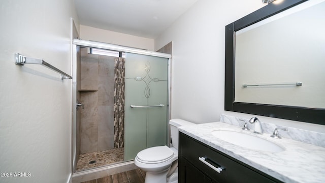 bathroom featuring toilet, an enclosed shower, and vanity