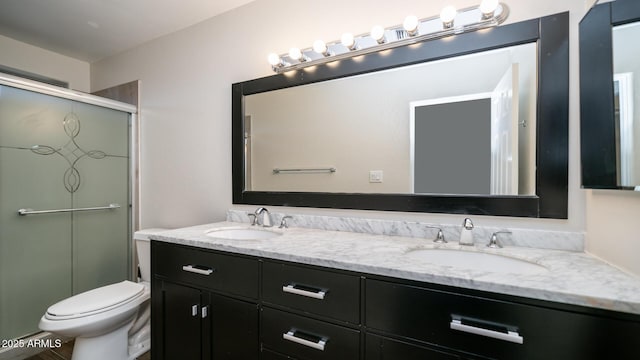 bathroom featuring an enclosed shower, vanity, and toilet