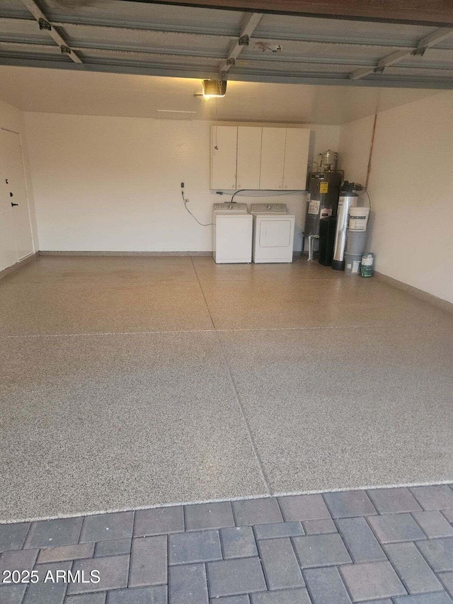 garage featuring gas water heater, electric water heater, and washing machine and clothes dryer