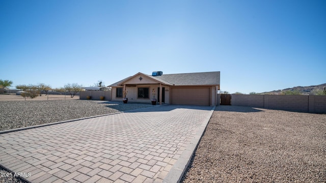 ranch-style house featuring central AC unit and a garage