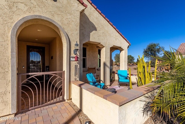 view of exterior entry with a patio