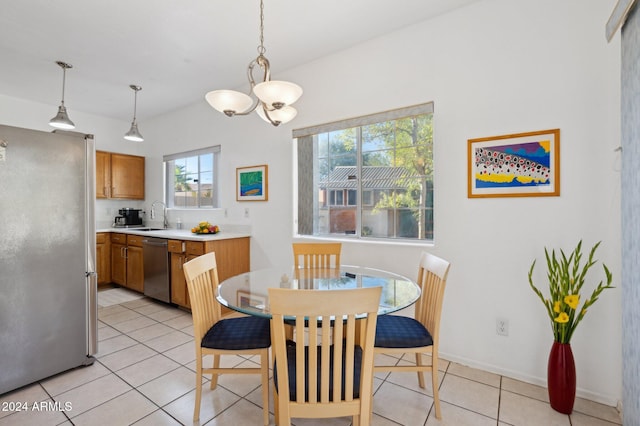 tiled dining space with an inviting chandelier, a wealth of natural light, and sink