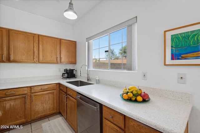 kitchen with light stone countertops, dishwasher, sink, pendant lighting, and light tile patterned floors