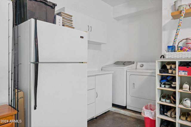 clothes washing area featuring cabinets and washing machine and clothes dryer