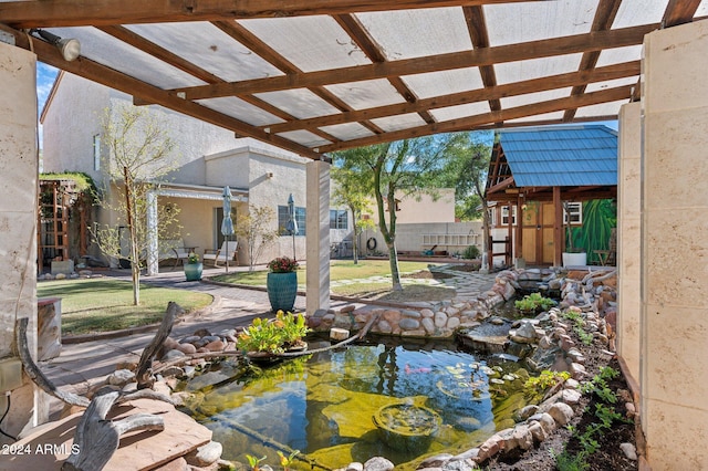 view of yard with a pergola, a garden pond, and a storage unit