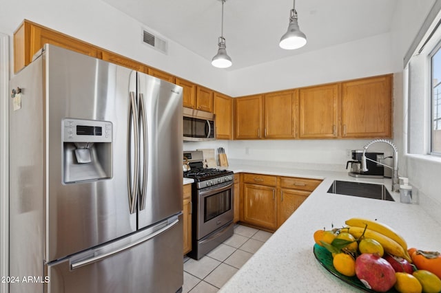 kitchen featuring pendant lighting, light tile patterned flooring, sink, and stainless steel appliances