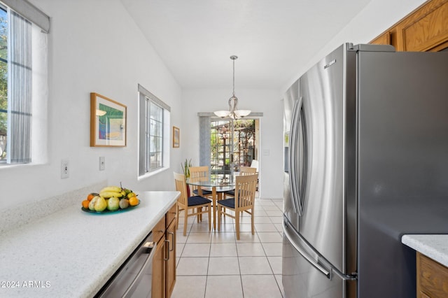 kitchen featuring decorative light fixtures, light tile patterned floors, plenty of natural light, and appliances with stainless steel finishes