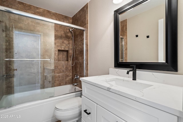 full bathroom featuring enclosed tub / shower combo, vanity, and toilet