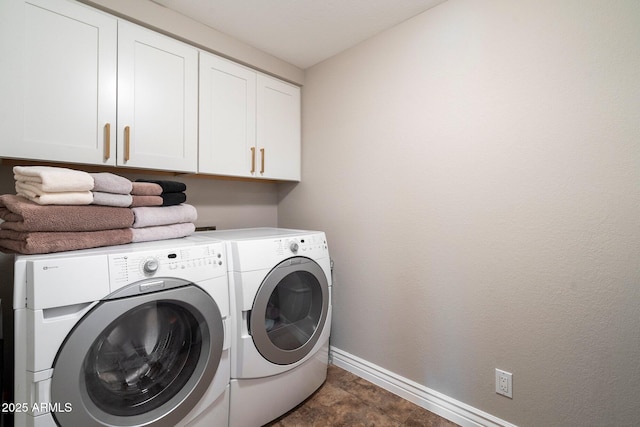 laundry area featuring washing machine and clothes dryer, cabinet space, and baseboards