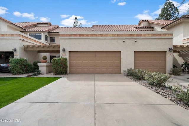 view of front of house featuring concrete driveway, a tile roof, an attached garage, and stucco siding