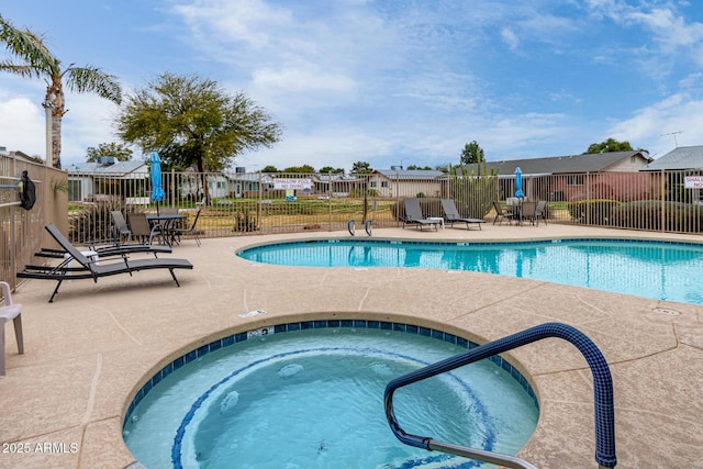 pool with a residential view, a hot tub, a patio, and fence